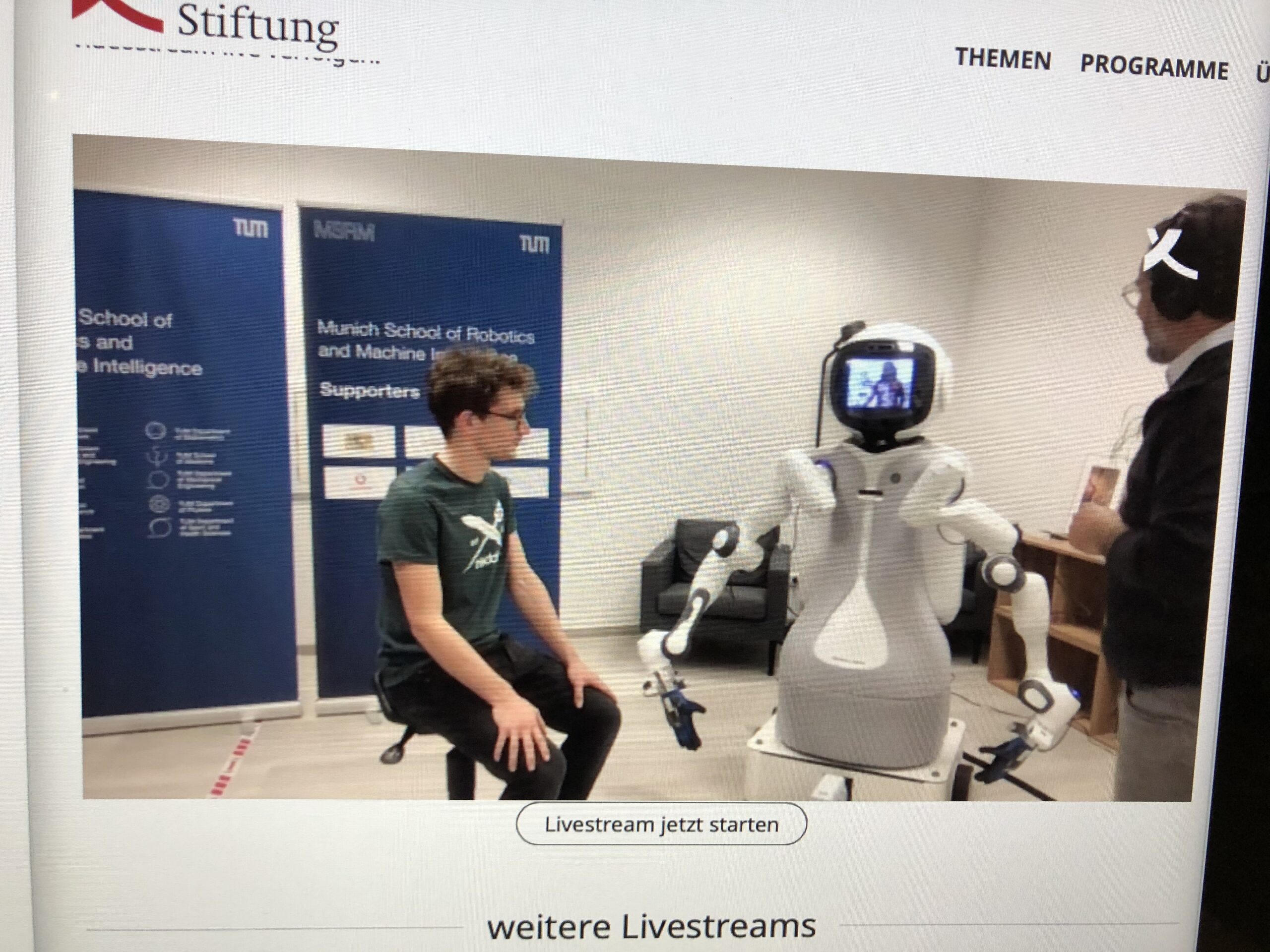 Der Arzt steuert den Roboter. Dieser tastet den patienten ab.